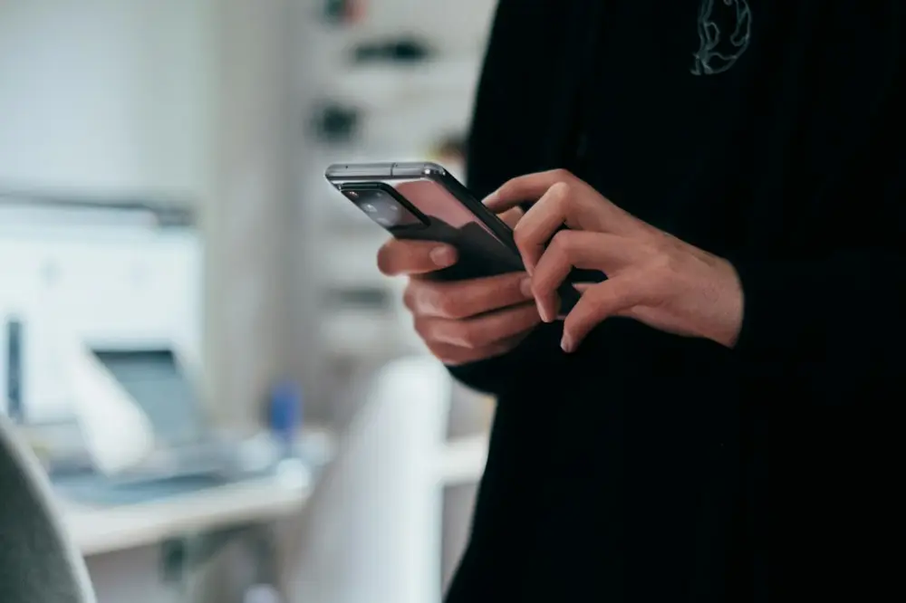Person holding black android smartphone, illustrating everyday phone habits